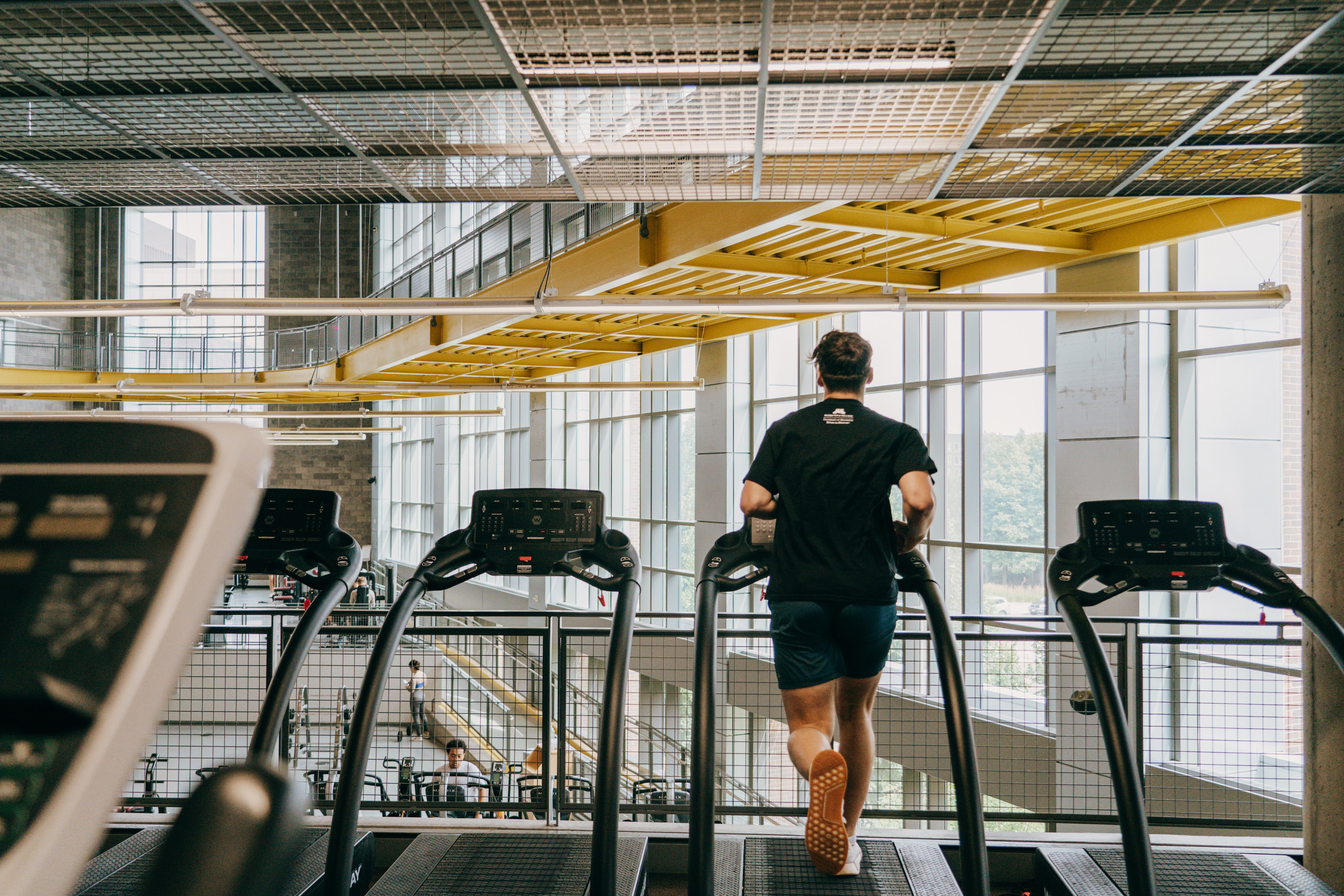 student running on treadmill over looking facility
