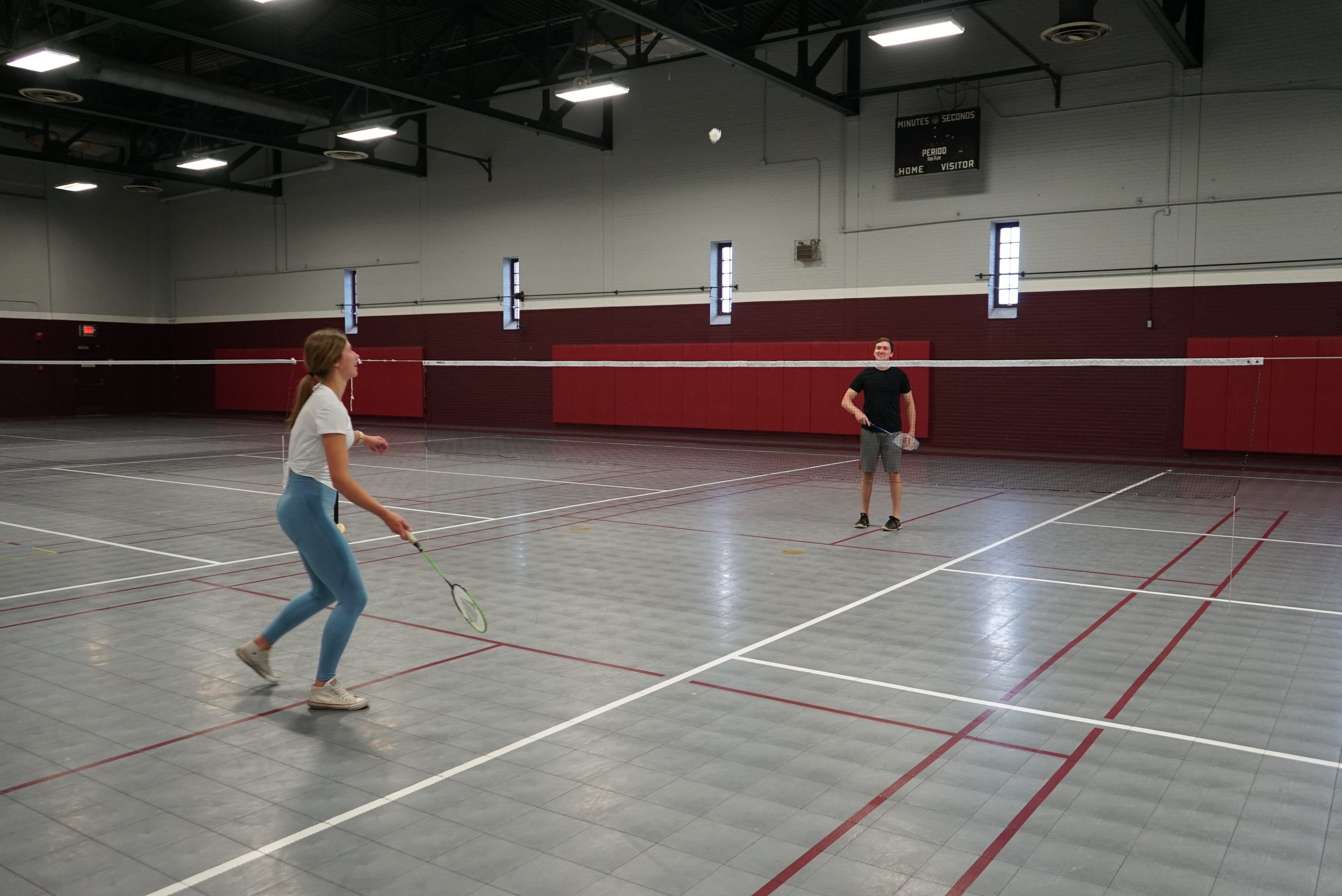 two students playing badminton in cooke hall
