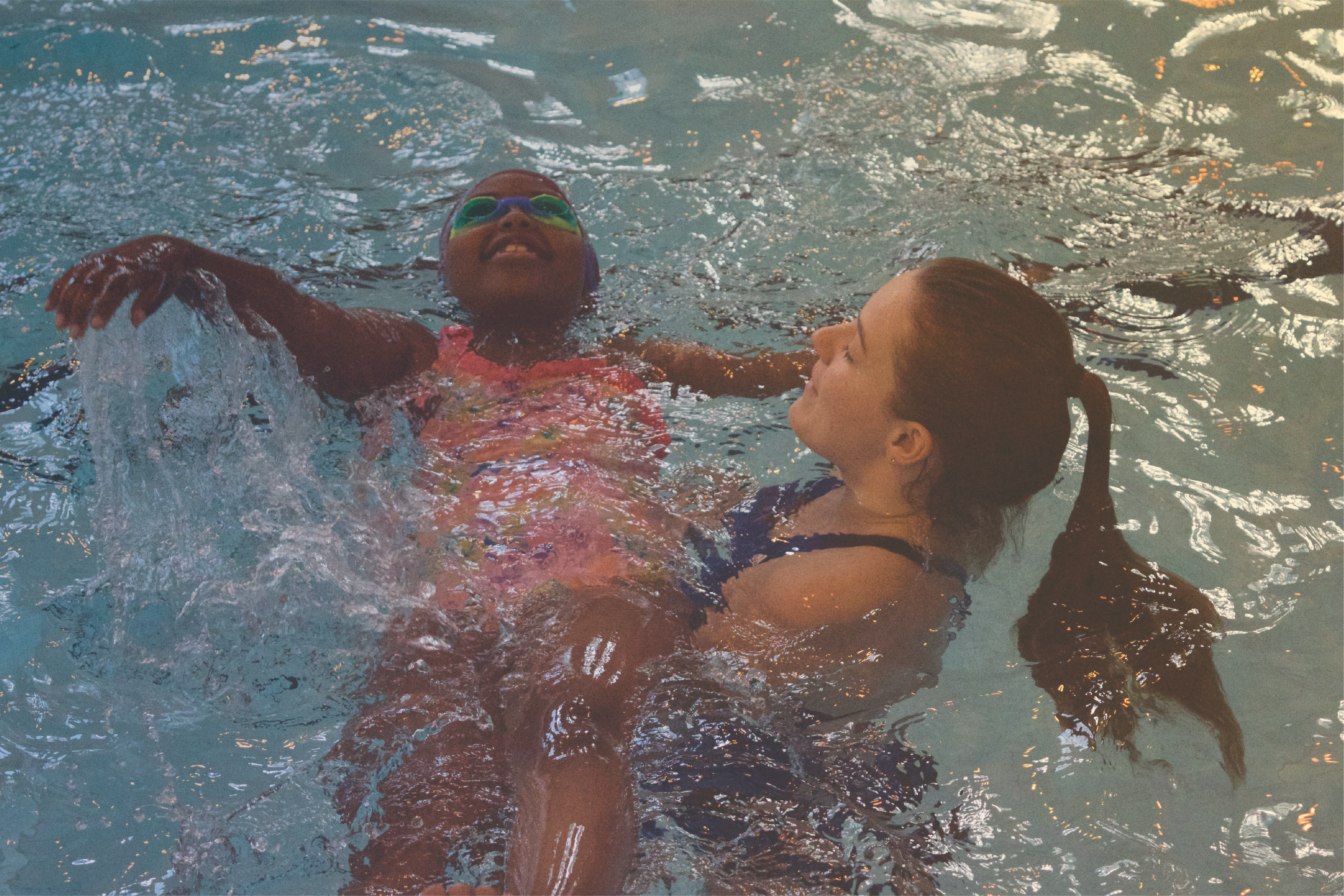 a young swimmer being helped by an instructor in a private lesson