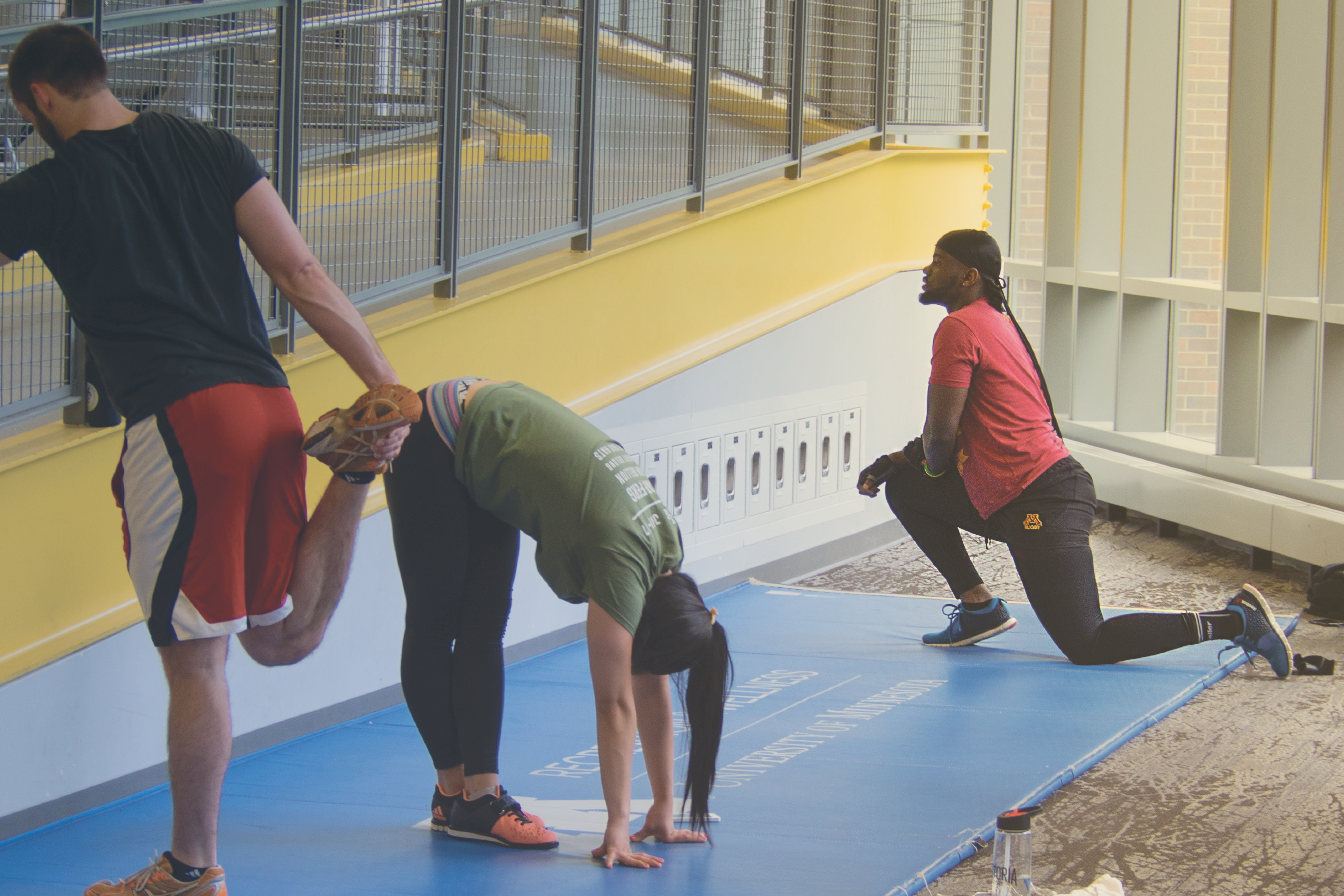 group of individuals stretching on the stretching mats on first floor of RecWell