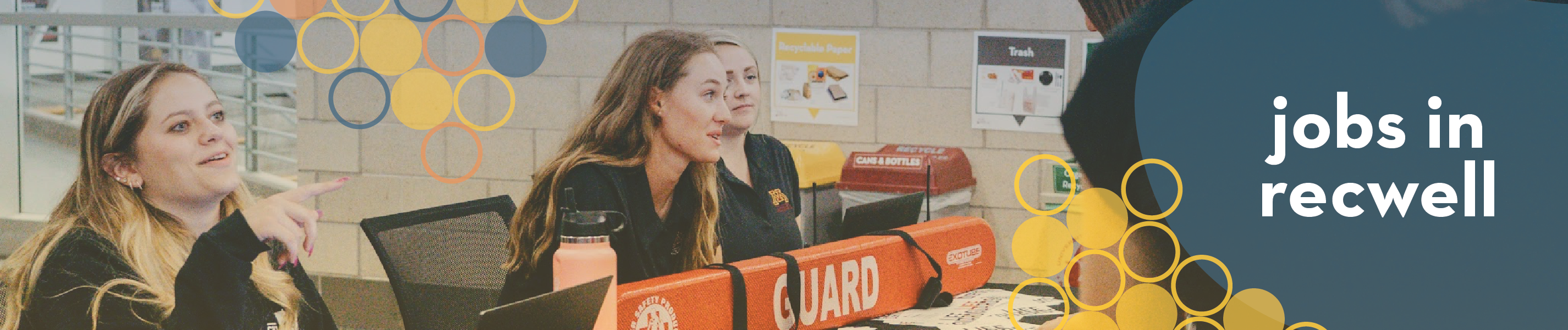 three students sitting at a table with a lifeguard rescue buoy with the text "jobs in recwell"