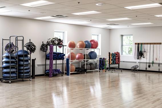 Room with windows, wood floors, and fitness equipment